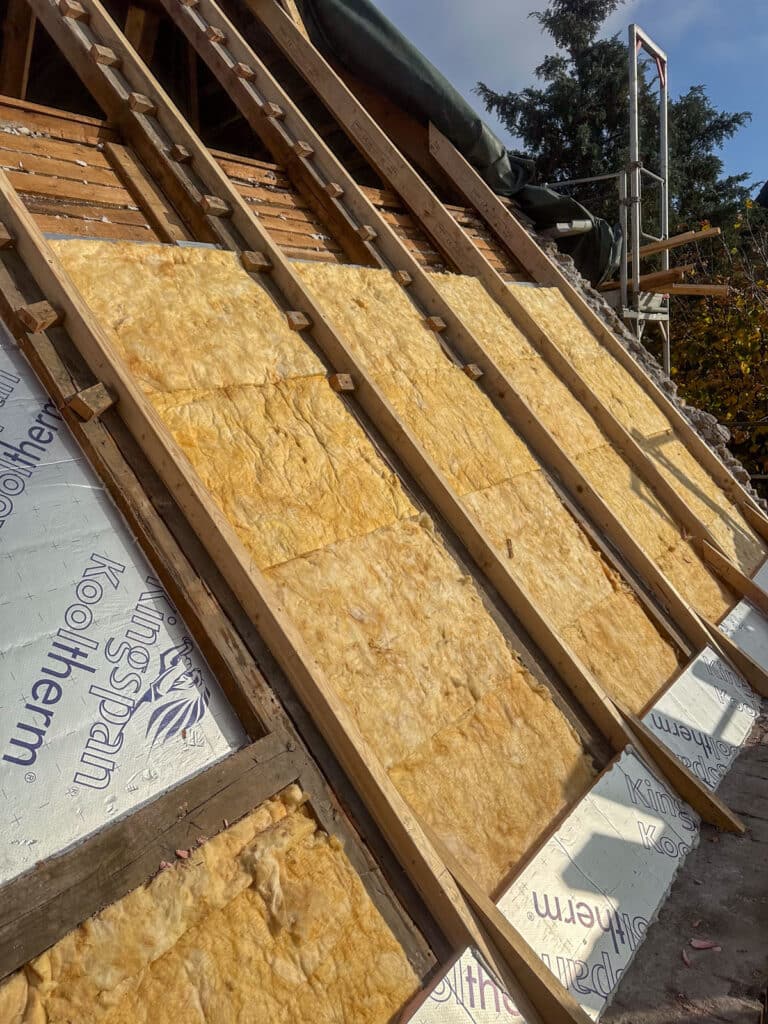 Efterisolering mellem spærene, mens taget er åbent, i Rødovre